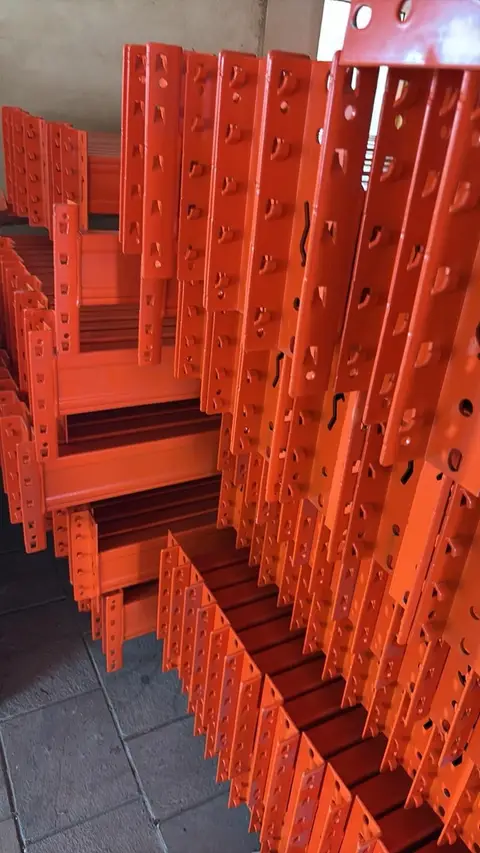 Stacks of orange beams showing their end connectors.