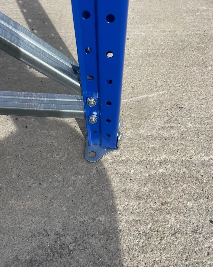 The foot of a blue upright: galvanised bracing bolted on above the footplate.