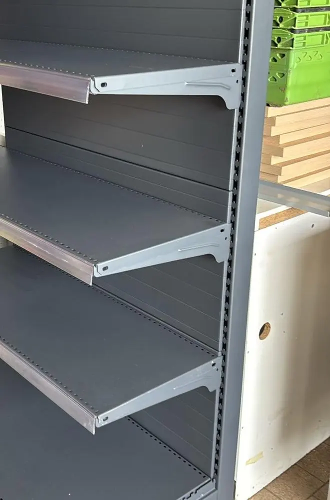 A grey shop shelving bay with five shelves and a back panel.